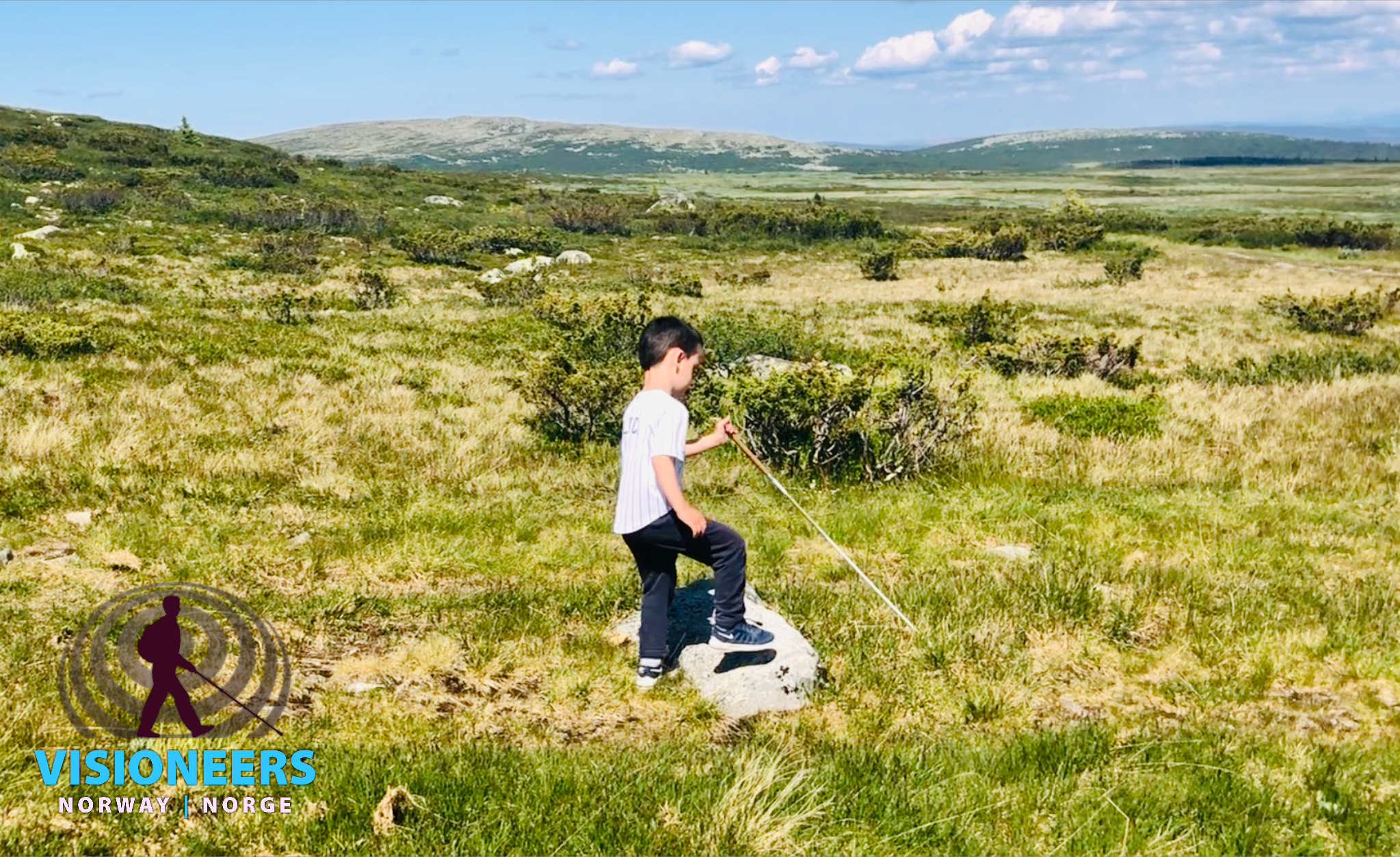 Visioneers-student på fire år som går med stokk på fjelltur